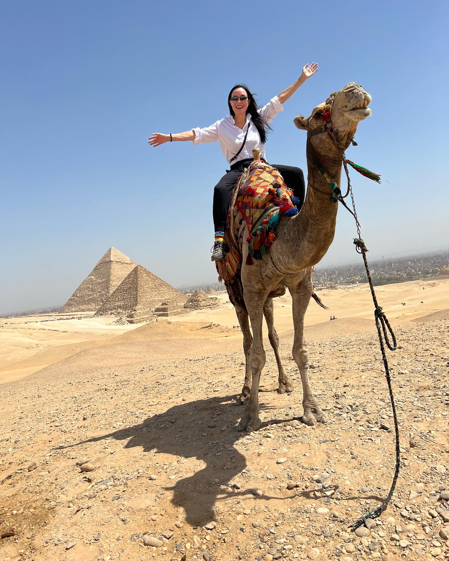 Michelle Calcote King on a camel in front of Egyptian pyramids