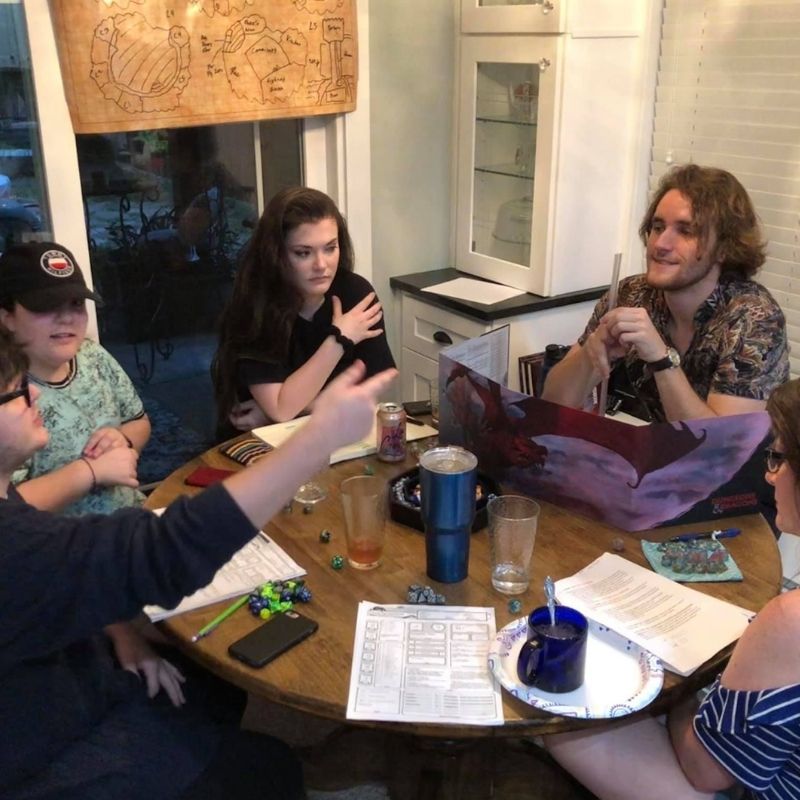 Group of people sitting at a table playing Dungeons & Dragons.