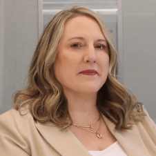 Amy Zelenka Headshot on a gray background