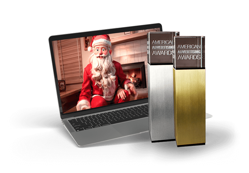 American Advertising awards next to a laptop with an award-winning video on the screen